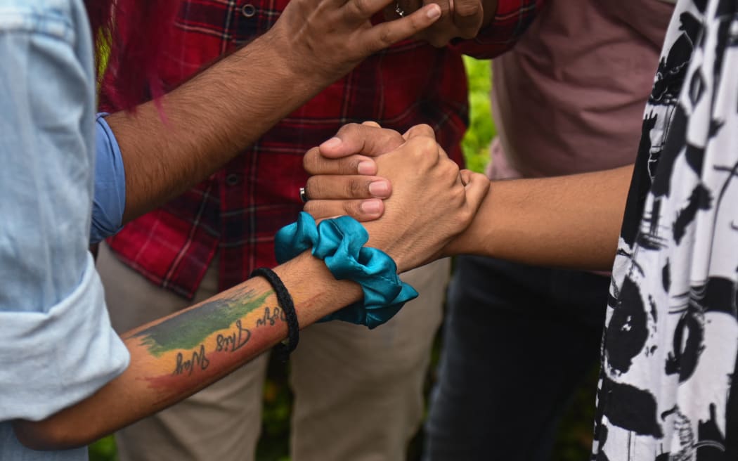 Members of the LGBTQ community hold hands while listening to the judgement on same-sex marriage by Supreme Court of India, in New Delhi, India on October 17, 2023. India's top court said on Tuesday that it cannot legalise same-sex marriages. (Photo by Kabir Jhangiani/NurPhoto) (Photo by Kabir Jhangiani / NurPhoto / NurPhoto via AFP)