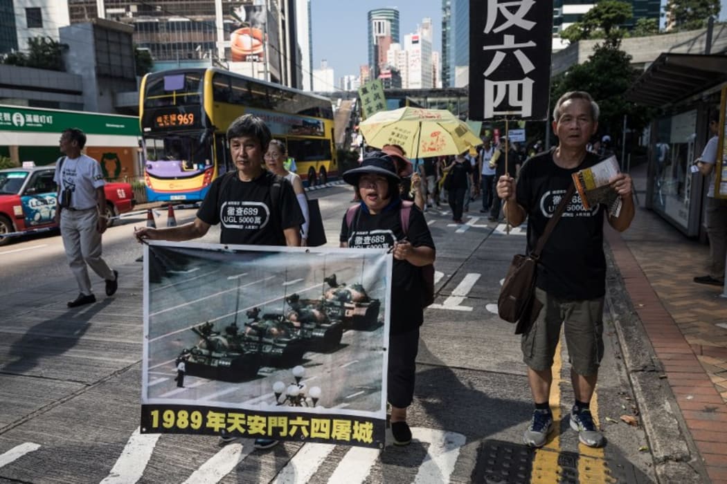 Protesters display a poster of the famous "Tank Man" standing in front of Chinese military tanks at Tiananmen Square in Beijing.