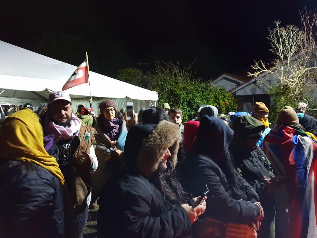 People gathered at Ihumātao on Monday evening after police deployed more officers to the scene.