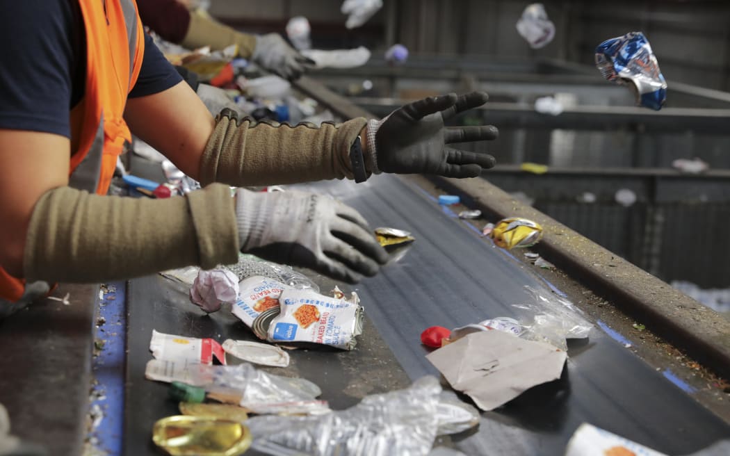 Workers sort through recycling by hand at the OJI Seaview Materials Recovery Facility in Lower Hutt