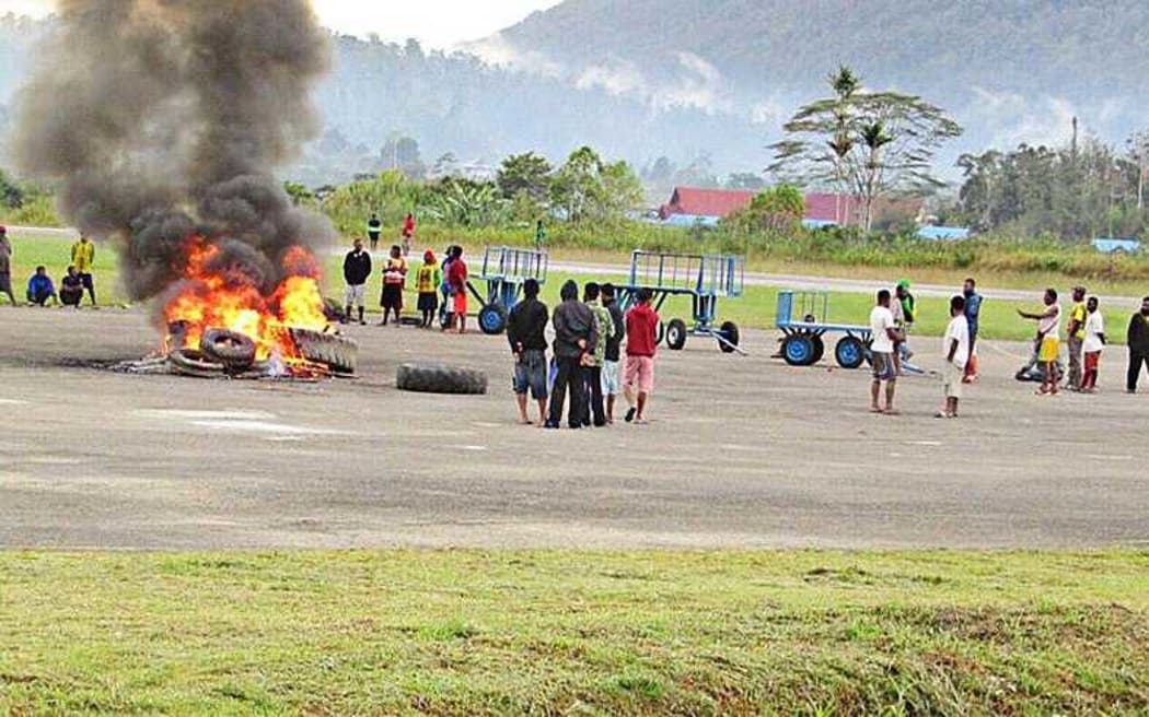 A group of angry residents set tires on fire at Oksibil Airport in Pegunungan Bintang regency, Papua, on November 18, 2017.