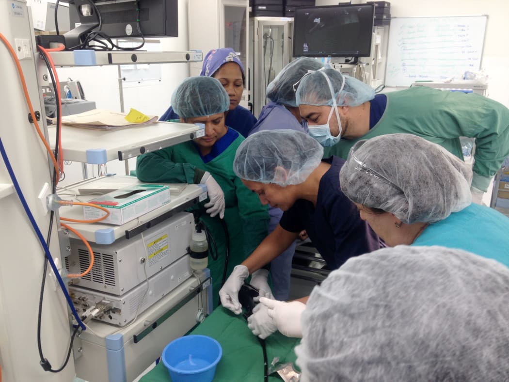 Dr Folototo Levai, Head of Medicine from Samoa is being taught a new skill by Dr Mai Ling Perman whilst ANZGITA nurse Karen Kempin (Dunedin) assists, and Dr David Motumanoa (Tonga) observes over shoulder.