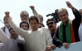 Pakistan cricketer-turned-politician Imran Khan (C) gestures as he heads a protest march from Lahore to Islamabad against the government, in Lahore on 14 August.