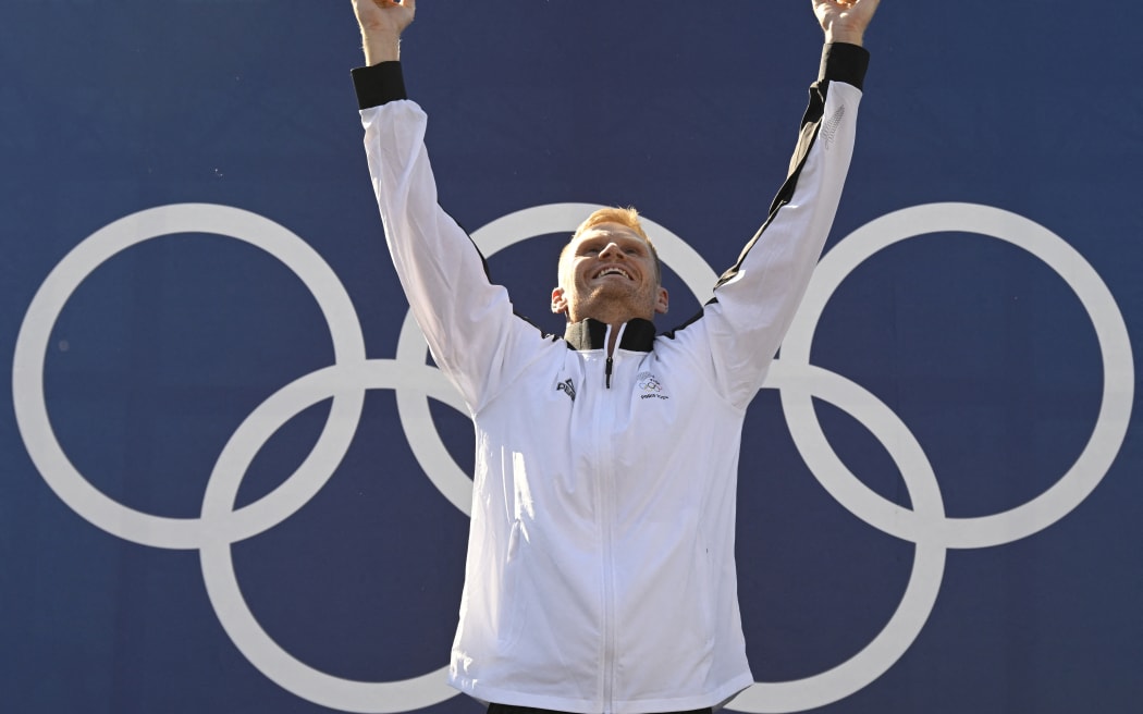 New Zealand's gold medallist Finn Butcher celebrates on the podium during the medal ceremony after the men's kayak cross final of the canoe slalom competition at Vaires-sur-Marne Nautical Stadium in Vaires-sur-Marne during the Paris 2024 Olympic Games on August 5, 2024. (Photo by Olivier MORIN / AFP)