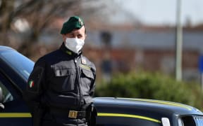 Italian police officer at a checkpoint at the small town of Zorlesco, southeast of Milan, on February 26, 2020.