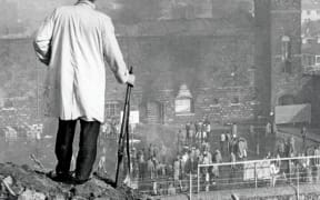 An armed offenders’ squad officer watches the riot.