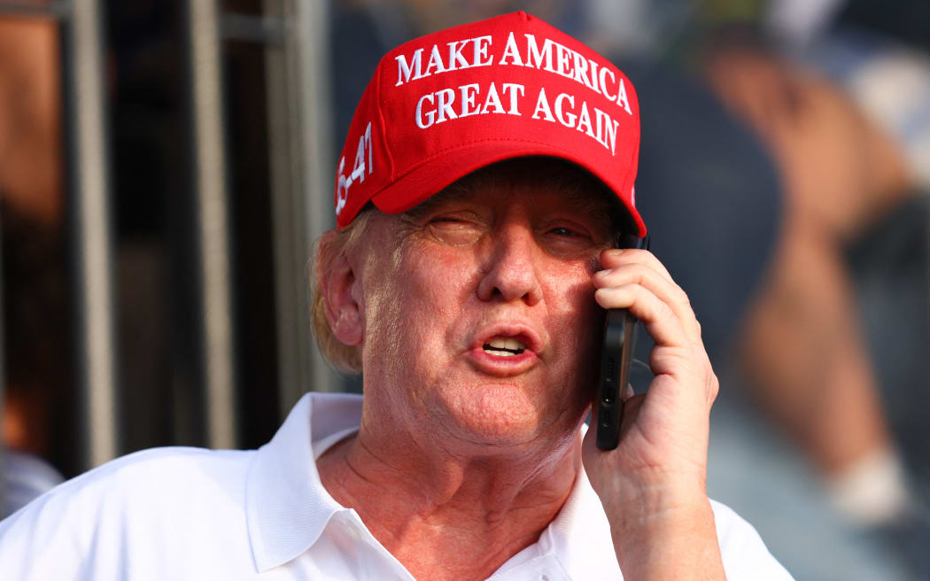 DORAL, FLORIDA - APRIL 07: Former U.S. President Donald Trump speaks on the phone at the 18th green during day three of the LIV Golf Invitational - Miami at Trump National Doral Miami on April 07, 2024 in Doral, Florida.   Megan Briggs/Getty Images/AFP (Photo by Megan Briggs / GETTY IMAGES NORTH AMERICA / Getty Images via AFP)
