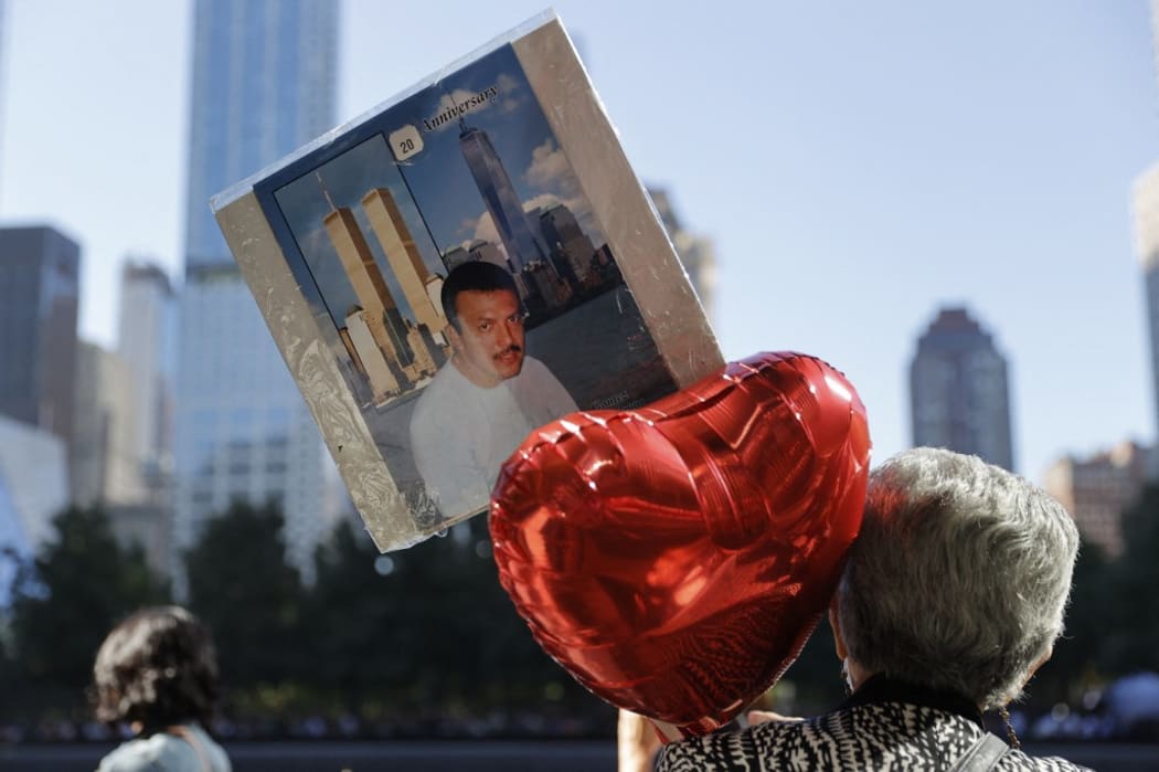 A person holding a balloon and a picture visits the 9/11 Memorial on the 20th anniversary of the September 11 attacks in Manhattan, New York on September 11, 2021.