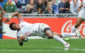 Tongan Atelea Okati of Tonga falls to the ground with the ball under pressure from Li Jialin of China during their match at the Hong Kong Sevens rugby tournament in Hong Kong on 27 March, 2010. Okati died following a car crash in December 2016.