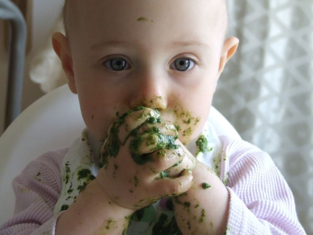 Baby eating green food