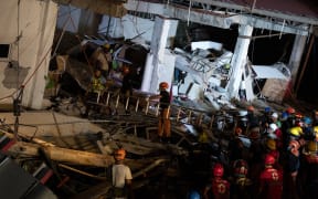 Rescue workers search for survivors in a collapsed Chuzon Super Market in Porac, Pampanga, after a powerful earthquake hit northern Philippines on April 22, 2019.