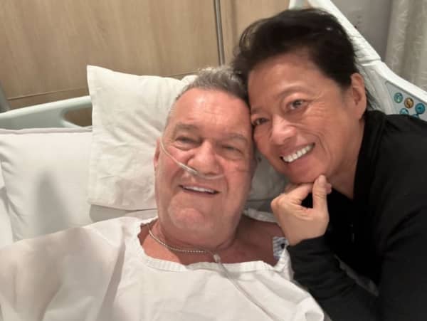 Jimmy Barnes in a hospital bed in August, 2024 with wife Jane Mahoney at his side.