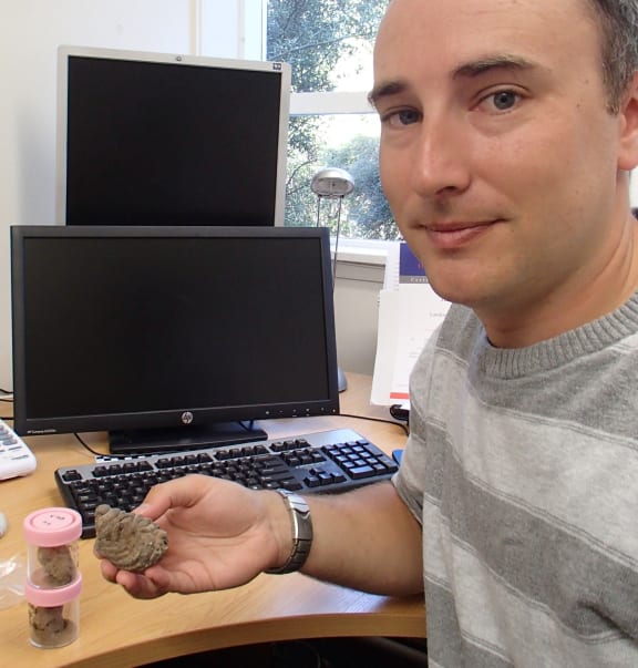 Jamie Wood has been studying coprolites - dried dung - and finding out interesting information about the genetics of birds such as moa as well as their diet. He is holding a moa coprolite.