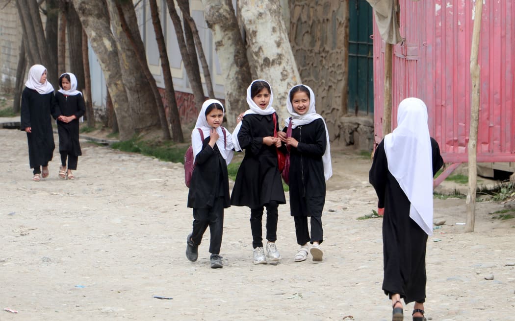 Afghan primary school girls walk to their school to attend the first class following the start of the new academic year, along a street in Fayzabad district, Badakhshan province on March 20, 2024. Schools in Afghanistan opened for the new academic year on March 20, the education ministry said, with girls banned from joining secondary-level classes for the third year in a row. (Photo by OMER ABRAR / AFP)