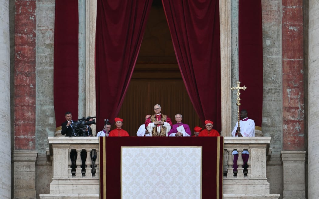 Newly elected Pope Robert Francis Prevost (C), Pope Leo XIV, arrives on the main central loggia balcony of the St Peter's Basilica for the first time, after the cardinals ended the conclave, in The Vatican, on May 8, 2025. Robert Francis Prevost was on May 8, 2025 elected the first pope from the United States, the Vatican announced. A moderate who was close to Pope Francis and spent years as a missionary in Peru, he becomes the Catholic Church's 267th pontiff, taking the papal name Leo XIV. (Photo by Stefano Rellandini / AFP)