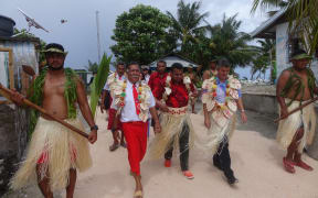 NZ Govt Minister Kris Faafoi welcomed onto Fakaofa in Tokelau. He is accompanied by NZ Administrator Ross Ardern and the Ulu O Tokelau Afega Gaualofa