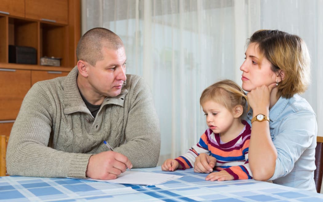 A photo of a sombre looking couple discussing divorce