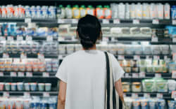 Rear view of young person doing grocery shopping.