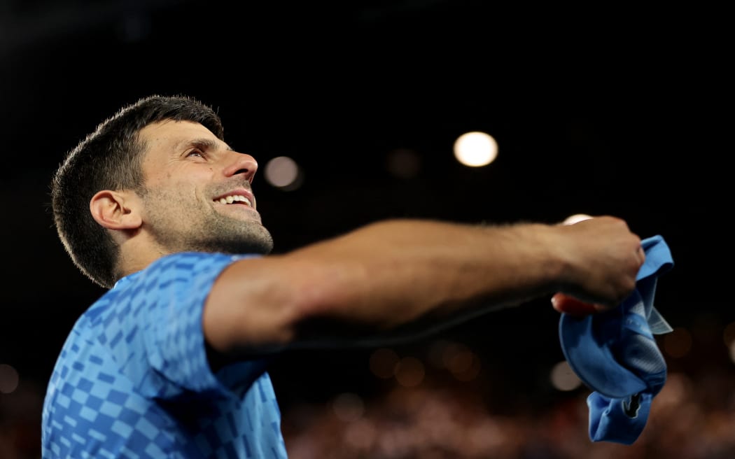Serbia's Novak Djokovic throws a cap towards a fan as he celebrates victory against Australia's Alex De Minaur after their men's singles match on day eight of the Australian Open tennis tournament in Melbourne.