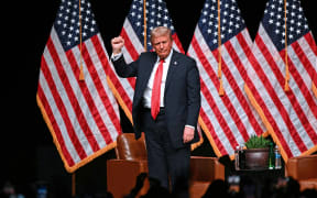 Former US President and Republican presidential candidate Donald Trump pumps his fist at the end of a live interview with US commentator Tucker Carlson in the finale of the Tucker Carlson Live Tour at Desert Diamond Arena in Glendale, Arizona, on October 31, 2024. (Photo by Patrick T. Fallon / AFP)
