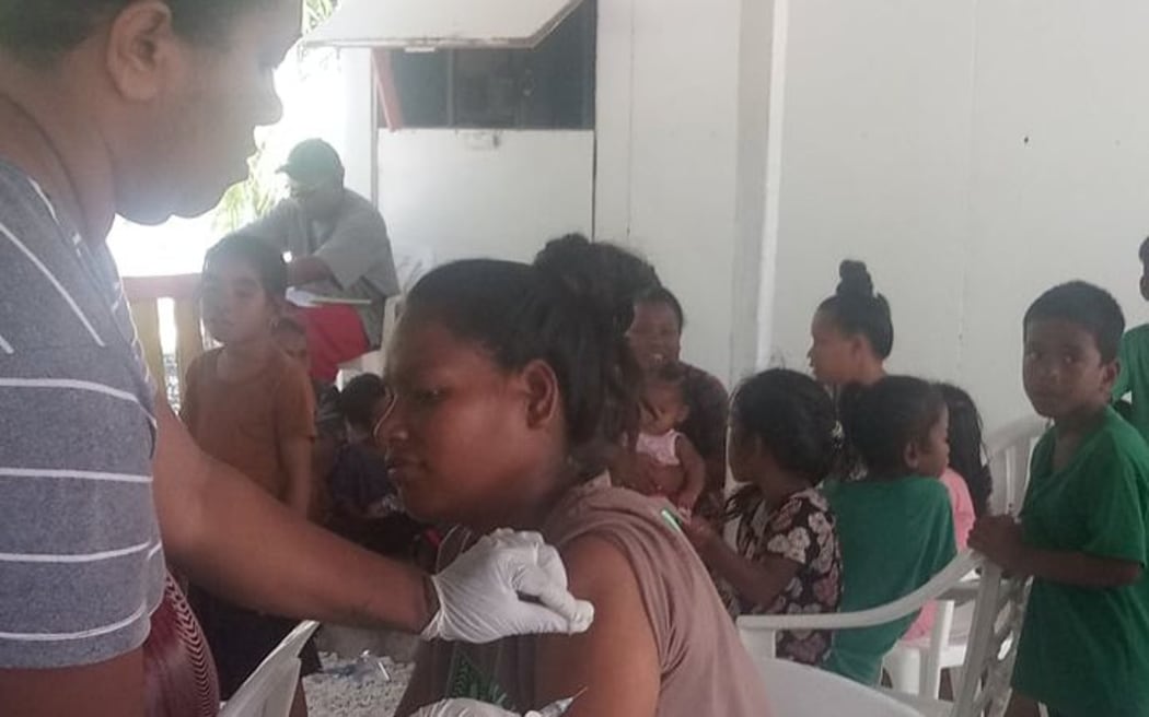 A Marshall Islands Ministry of Health and Human Services nurse gives the first Johnson & Johnson vaccine on Lib Island on April 8. Since dispensing the Johnson & Johnson vaccine at Lib Island, the ministry has paused its use and stationed nurses on the distant island to monitor the population