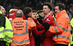 Liverpool's Curtis Jones is held back by stewards as he remonstrates with Everton players after the final Merseyside derby at Goodison Park.