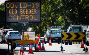 This file photo taken on April 15, 2020 shows a COVID-19 coronavirus sign at a Pacific Highway vehicle checkpoint on the Queensland-New South Wales state border near Coolangatta.