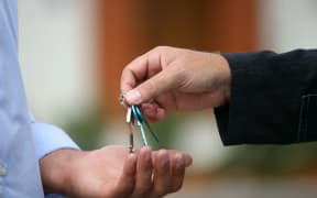 Estate agent handing over keys to house