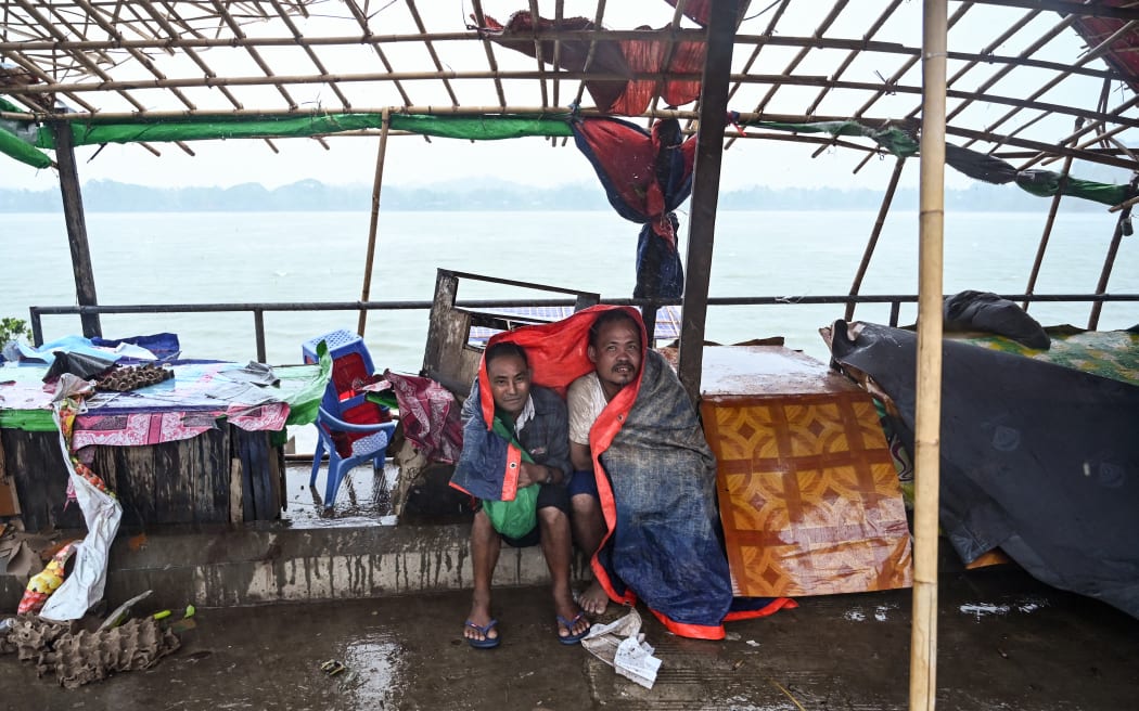 People take shelter in Kyauktaw in Myanmar’s Rakhine state on 14 May, 2023, as Cyclone Mocha crashes ashore.