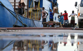 Vanuatu disaster management staff loading donated goods onto a ship heading to Ambae to help with evacuations.