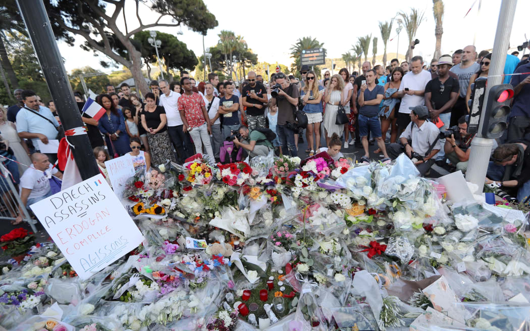 People gather around a makeshift memorial to pay their respects.