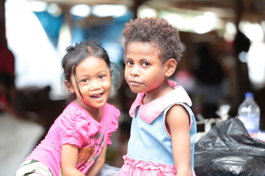 Indonesian and West Papuan girls play in a market in Jayapura.