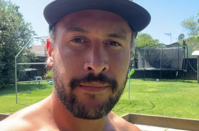 Jordan Watson has a beard and a slight smile and wears a baseball cap.