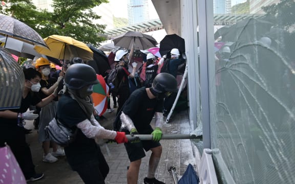 Protesters attempt to break a window at the government headquarters in Hong Kong.