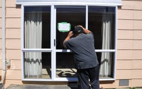 Pat Koti looks into his yellow-stickered rental home that was damaged during the floods in Westport.
