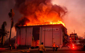 A Bank of America is fully engulfed in flames along Lake Ave. during the Eaton fire in the Altadena area of Los Angeles county, California on January 8, 2025. - At least five people are now known to have died in wildfires raging around Los Angeles, with more deaths feared, law enforcement said January 8, as terrifying blazes leveled whole streets, torching cars and houses in minutes.
More than 1,000 buildings have burned in multiple wildfires that have erupted around America's second biggest city, forcing tens of thousands of people from their homes. (Photo by JOSH EDELSON / AFP)