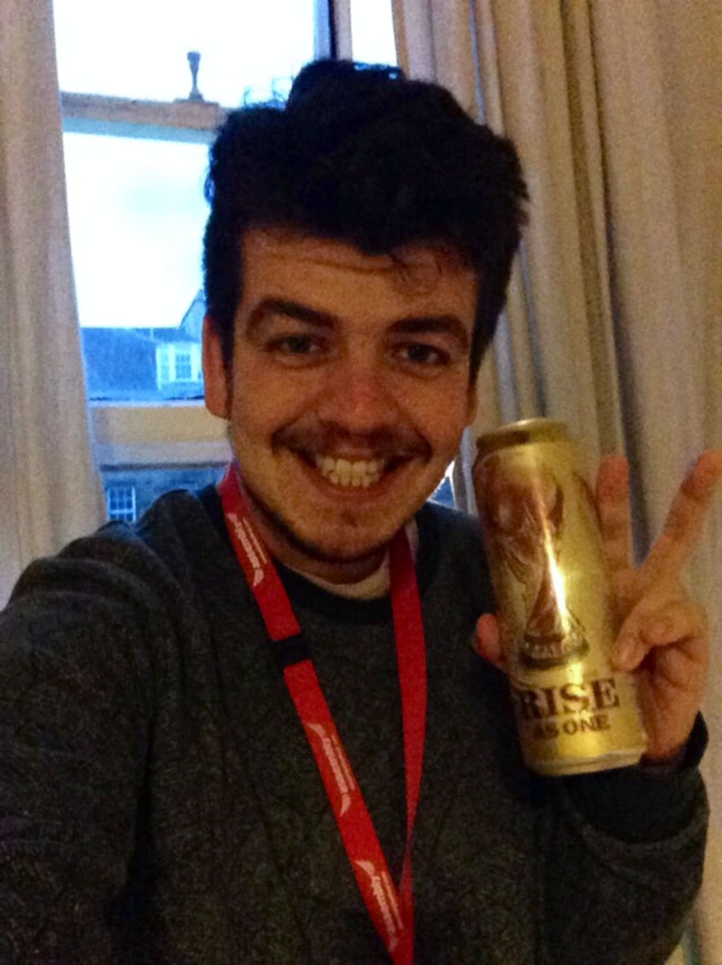A picture of Joseph Moore with a World Cup commemorative beer