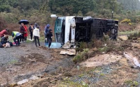 People support one another at the bus crash near Rotorua that has killed at least five people.
