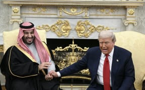 US President Donald Trump jokes about hand shakes and fist pumps with Crown Prince and Prime Minister of the Kingdom of Saudi Arabia Mohammed bin Salman during a meeting in the Oval Office of the White House in Washington, DC on 18 November, 2025.