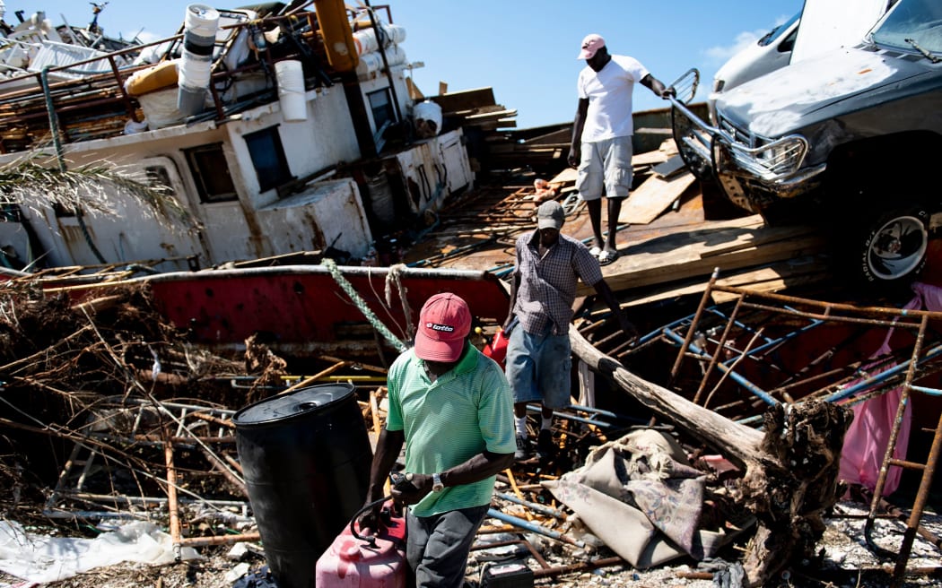 People recover items from a beached boat after Hurricane Dorian September 5, 2019, in Marsh Harbor, Great Abaco.