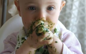 Baby eating green food