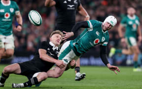 Ireland's Mack Hansen is tackled by All Black Damian McKenzie.
