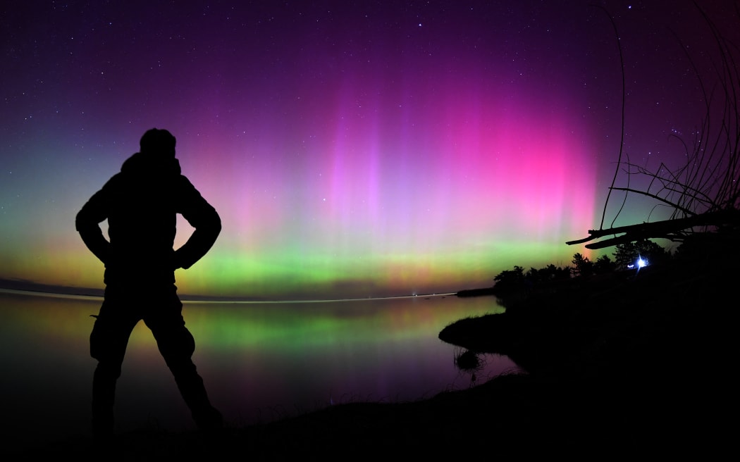 The Aurora Australis, also known as the Southern Lights, glow on the horizon over waters of Lake Ellesmere on the outskirts of Christchurch on May 11, 2024. The most powerful solar storm in more than two decades struck Earth, triggering spectacular celestial light shows from Tasmania to Britain -- and threatening possible disruptions to satellites and power grids as it persists into the weekend.