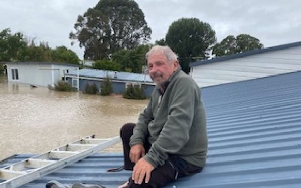 Mike Brown waits on the roof of his Pakowhai home to be rescued.