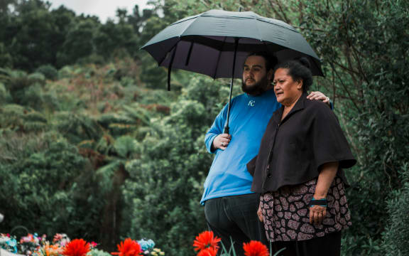 Albert and Lina Fairbrother stand under an umbrella at Taita Cemetery
