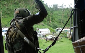 The NH90 hovering over a remote village, ready to land and drop in aid