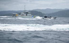 A RSIPF patrol boat and fast craft patrolling the Solomon Islands side of the common border with PNG with Bougainville in the background.