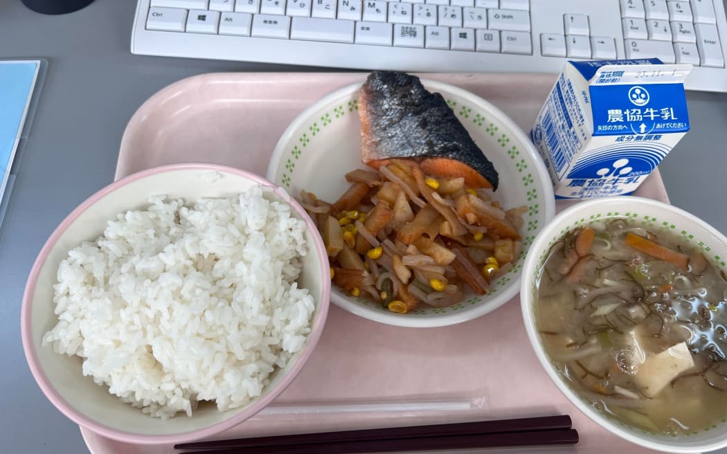 A meal from Kyuushoku (the Japanese school lunch programme), featuring tofu miso soup, rice, vegetables and salmon.