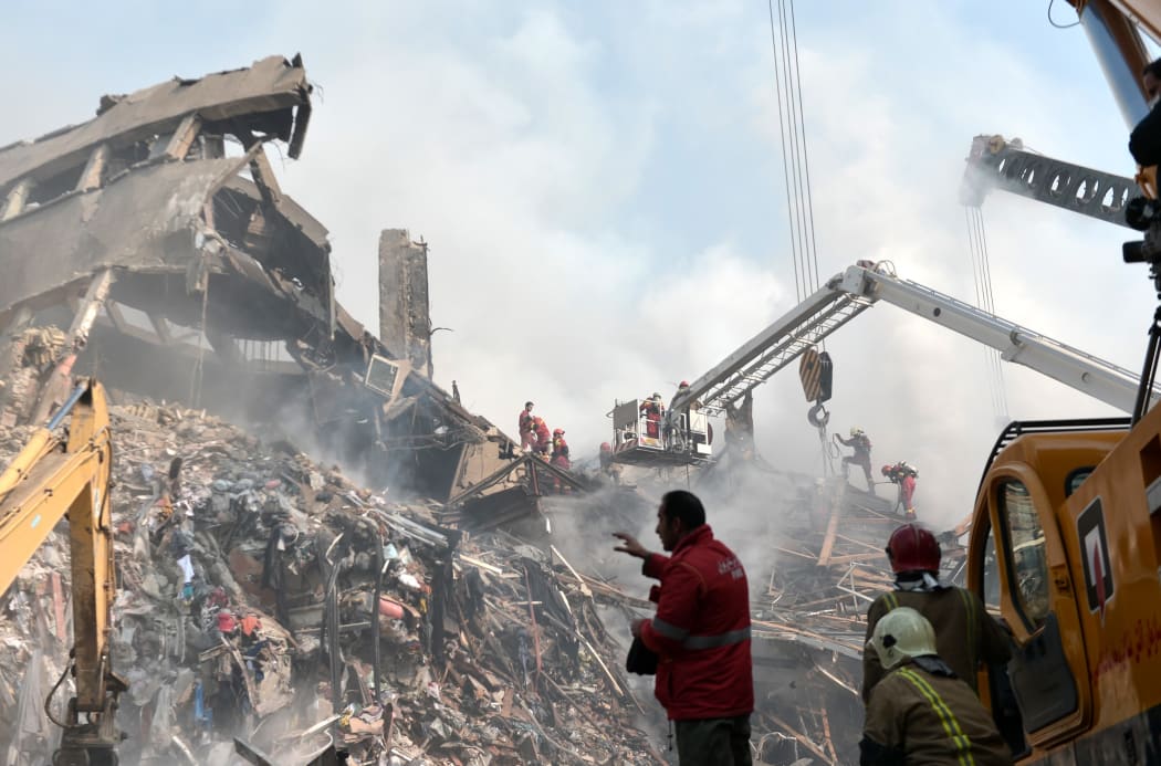 Search and rescue teams at the site of the Plasco Tower, in Tehran a day after the building caught fire and collapsed, killingat least 20 firefighters.