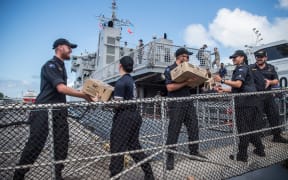 Military personnel offload aid supplies in Fiji.